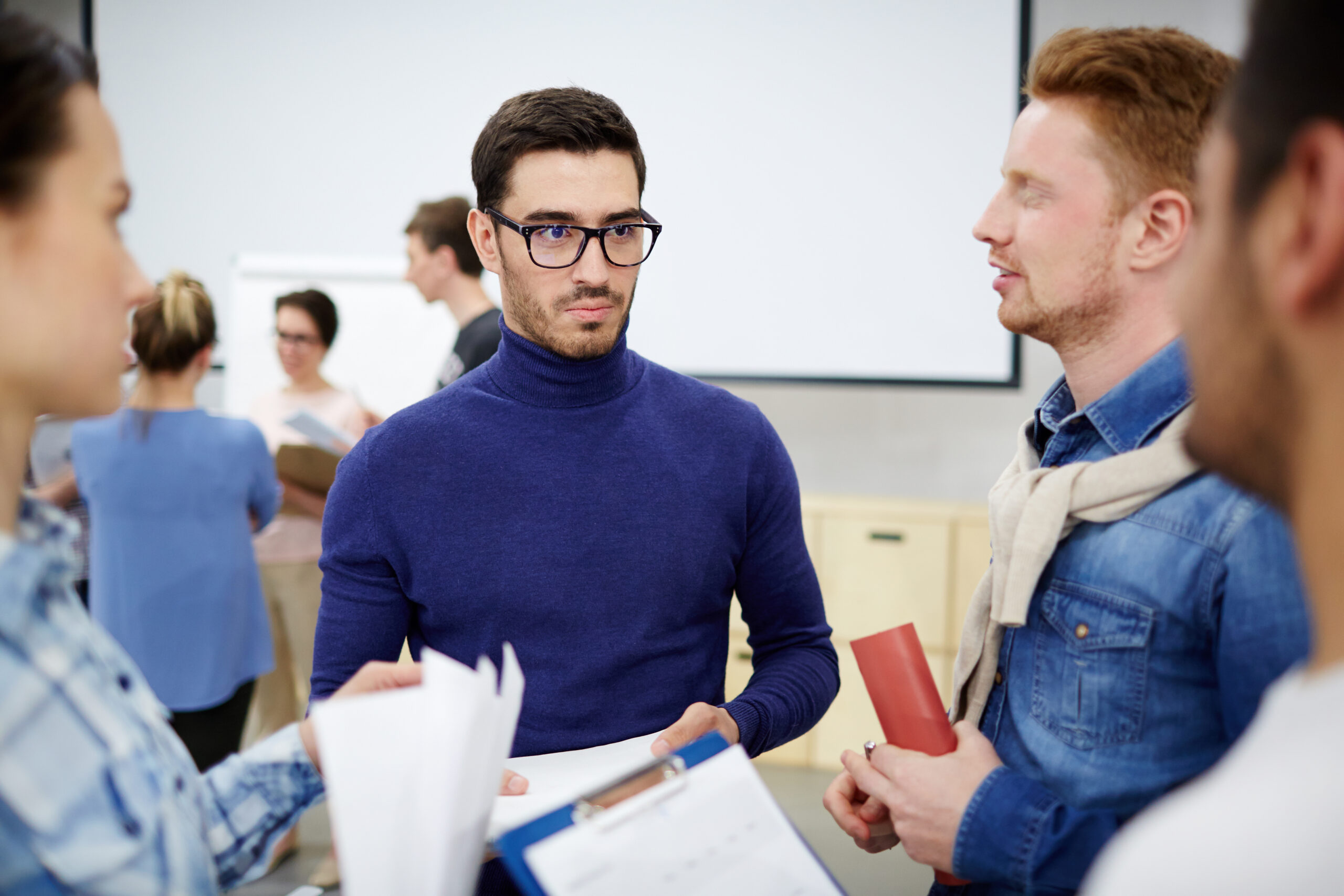 Confident student listening to ideas of his groupmates during discussion of suggestions